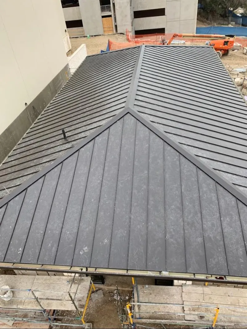 Commercial metal roof construction with crane equipment in Barrington